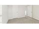 Bright bedroom with neutral walls, gray carpet, and view of a hallway through an open doorway at 621 White Birch Ln, Angier, NC 27501