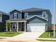 Lovely two-story home showcasing blue siding, a welcoming porch, and a two-car garage at 621 White Birch Ln, Angier, NC 27501