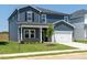 Charming two-story home showcasing blue siding, a welcoming porch, and a well-manicured lawn at 621 White Birch Ln, Angier, NC 27501