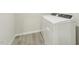 Bright laundry room features modern washer and dryer, complemented by stylish wood-look flooring at 621 White Birch Ln, Angier, NC 27501