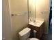 Bright bathroom with a single sink vanity, toilet, and a large mirror at 70 Ariel St, Lillington, NC 27546