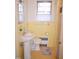 Quaint bathroom with yellow tiled walls and floors, featuring a pedestal sink, toilet, and vintage fixtures at 711 Evergreen Rd, Rocky Mount, NC 27803