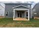 View of the home's rear exterior with a covered patio and well-maintained lawn at 766 Old Station Pointe, Angier, NC 27501