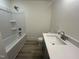 A full bathroom with a single sink vanity, quartz countertop, bathtub and vinyl flooring at 766 Old Station Pointe, Angier, NC 27501
