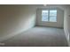 Bright bedroom featuring neutral carpet, white walls, and natural light from a single window at 766 Old Station Pointe, Angier, NC 27501