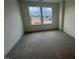 A cozy bedroom with neutral carpet, base molding, and natural light from the double windows at 766 Old Station Pointe, Angier, NC 27501