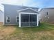 Exterior view showing the home's screened-in porch, well-kept lawn and grey siding at 766 Old Station Pointe, Angier, NC 27501