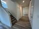 Hallway with wood floors, white trim, and staircase leading to the upper level at 766 Old Station Pointe, Angier, NC 27501