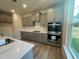 This kitchen features stainless appliances, gray cabinets, quartz countertops, and modern recessed lighting at 766 Old Station Pointe, Angier, NC 27501