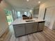 A new kitchen island with gray cabinets, stainless dishwasher, stainless sink, and quartz countertops at 766 Old Station Pointe, Angier, NC 27501