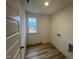 This laundry room features wood-style floors and a window with neighborhood views at 766 Old Station Pointe, Angier, NC 27501