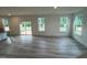 Large living room area with wood flooring, sliding glass doors, and three large windows at 766 Old Station Pointe, Angier, NC 27501