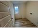 Small room with wood floor, a window providing natural light, and utility connections; ideal for laundry at 766 Old Station Pointe, Angier, NC 27501