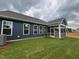 Inviting screened-in porch extending from the home, surrounded by a newly laid lawn and dark blue siding at 771 Old Station Pointe, Angier, NC 27501