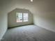 Spacious bedroom with carpet, white trim, and window overlooking new homes under construction at 771 Old Station Pointe, Angier, NC 27501