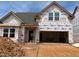 New construction home with gray roof and white building wrap, awaiting finishing touches at 771 Old Station Pointe, Angier, NC 27501