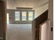 Bright, unfinished living room space showcasing large windows and natural light at 771 Old Station Pointe, Angier, NC 27501