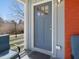 Blue front door, brick pillar, and seating area on the covered front porch at 774 Cornelius St, Hillsborough, NC 27278