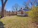 Cozy blue cottage featuring a welcoming covered porch, set on a large, grassy lot at 774 Cornelius St, Hillsborough, NC 27278