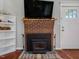 Close-up of a brick fireplace with a wood-burning stove and a wood beam mantel at 774 Cornelius St, Hillsborough, NC 27278