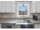 Close-up of the stainless steel farm sink and faucet with granite countertops and white cabinets at 774 Cornelius St, Hillsborough, NC 27278