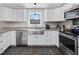 The kitchen boasts stainless steel appliances, sleek white cabinetry, and stylish granite countertops at 774 Cornelius St, Hillsborough, NC 27278