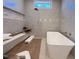 New construction primary bathroom showing freestanding soaking tub with modern fixtures and window at 7808 Ailesbury Rd, Wake Forest, NC 27587