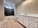 Bright bathroom with modern vanity, large mirror, and bathtub with dark tile surround at 7808 Ailesbury Rd, Wake Forest, NC 27587