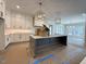 Spacious kitchen with white cabinets, a large island, and modern pendant lighting fixtures at 7808 Ailesbury Rd, Wake Forest, NC 27587