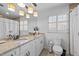 Bright bathroom featuring double vanity with granite countertop, and classic white cabinets and fixtures at 8000 N Bridgewater Ct, Raleigh, NC 27615