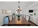 Bright dining room features a long wood table, chandelier, and view into the living room with fireplace at 8000 N Bridgewater Ct, Raleigh, NC 27615