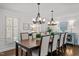 Well-lit dining room featuring a large wooden table, modern chandeliers, and refined decor at 8000 N Bridgewater Ct, Raleigh, NC 27615