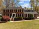 Charming brick home with classic black shutters and a lush front lawn, offering a welcoming ambiance at 8000 N Bridgewater Ct, Raleigh, NC 27615