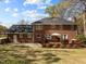 Exterior view of a brick home with a spacious backyard and deck at 8000 N Bridgewater Ct, Raleigh, NC 27615