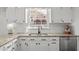 White kitchen with granite countertops, stainless appliances, and view of the backyard from the window at 8000 N Bridgewater Ct, Raleigh, NC 27615