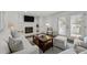 Living room with white brick fireplace and hearth, tv, french doors, and comfortable seating at 8000 N Bridgewater Ct, Raleigh, NC 27615