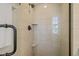 Neutral tiled shower with glass door, shower shelves and a hand shower at 8000 N Bridgewater Ct, Raleigh, NC 27615