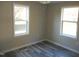 A bedroom with gray walls, gray floors, two windows, and a ceiling fan at 912 Martin Luther King Jr Dr, Smithfield, NC 27577