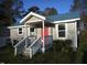 Charming one-story home with a blue metal roof, covered porch, and inviting red door at 912 Martin Luther King Jr Dr, Smithfield, NC 27577