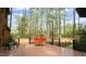 Back deck with wooden floor, modern seating, and forest view at 917 Queensferry Rd, Cary, NC 27511