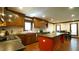 Spacious kitchen with wooden cabinets, a red island, stainless steel appliances, and hardwood floors at 917 Queensferry Rd, Cary, NC 27511