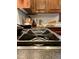 A close-up view of the cooktop features stainless steel appliances, dark countertops, and a white tile backsplash at 917 Queensferry Rd, Cary, NC 27511
