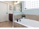Bright bathroom featuring a soaking tub, neutral tile, and framed art prints on the cool blue walls at 921 Marshall Farm St, Wake Forest, NC 27587