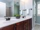 Bathroom with double sink vanity featuring dark wood cabinets, a tile shower and a window for ample light at 921 Marshall Farm St, Wake Forest, NC 27587