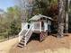 Fun playhouse with rock climbing wall and slide nestled among the trees in the backyard at 921 Marshall Farm St, Wake Forest, NC 27587