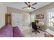 Bedroom with neutral walls, a ceiling fan, and view of the exterior scenery through large windows at 97 Silver Creek Dr, Clayton, NC 27520