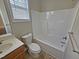 Bathroom with a tub and shower, a toilet, a vanity sink, and a window at 1036 Steelhorse Dr, Fuquay Varina, NC 27526