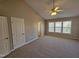 Spacious bedroom featuring carpet, a ceiling fan, and multiple windows for ample natural light at 1036 Steelhorse Dr, Fuquay Varina, NC 27526