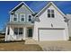 Charming two-story home featuring a two-car garage, inviting porch, and stylish design elements at 1036 Steelhorse Dr, Fuquay Varina, NC 27526