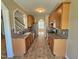 Functional galley kitchen with wood cabinets, granite counters, and modern appliances at 1036 Steelhorse Dr, Fuquay Varina, NC 27526